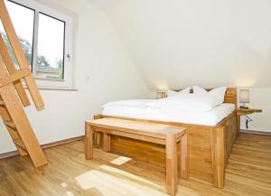a bedroom with a bed with a bench and a window at Heimathafen An Seen & Meer in Korswandt