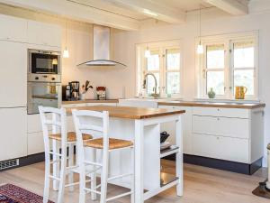 a kitchen with a wooden table and white cabinets at 8 person holiday home in Vig in Vig