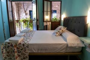 a bed in a room with two windows at Puerta de la Luna in Córdoba