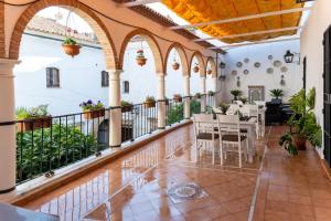 a room with a balcony with tables and chairs at Puerta de la Luna in Córdoba