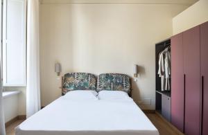 Dormitorio con cama grande y cabecero colorido en Dimora Fortebraccio en LʼAquila