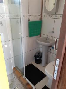 a small bathroom with a sink and a toilet at Casas Ferrugem-Garopaba in Garopaba