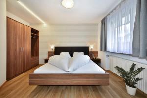 a bedroom with a bed with white sheets and a window at Alpenchalet Niederkofler Marilena in San Giovanni in Val Aurina