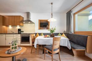 een keuken en eetkamer met een tafel en een bank bij Alpenchalet Niederkofler Evita in San Giovanni in Val Aurina