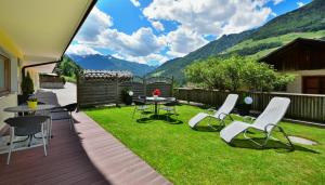 patio con tavolo e sedie sull'erba di Alpenchalet Niederkofler Vera a San Giovanni in Val Aurina