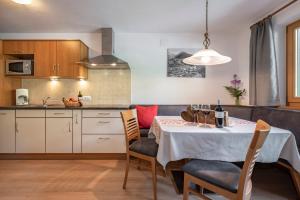 una cucina e una sala da pranzo con tavolo e sedie di Alpenchalet Niederkofler Vera a San Giovanni in Val Aurina
