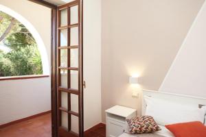 a bedroom with a bed and a window at Country Villa San Vito Bay in San Vito lo Capo