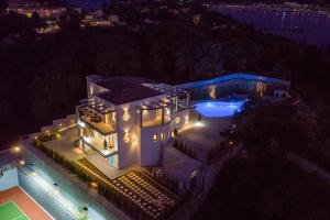 an aerial view of a house with a pool at night at Five Stars Villa in Kommeno