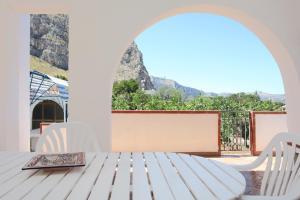 a table with chairs and a view of the mountains at Country Villa San Vito Bay in San Vito lo Capo