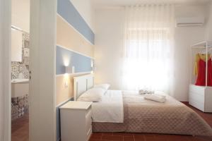 a white bedroom with a bed and a window at Country Villa San Vito Bay in San Vito lo Capo