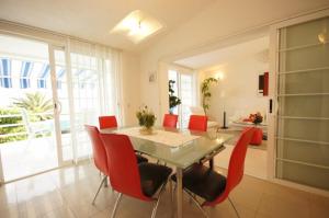 een eetkamer met een tafel en rode stoelen bij Grego apartments in Viganj