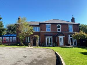 a large brick house with a driveway in front of it at Borrowfield Lodge in Derby