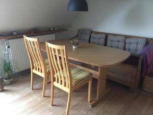 drewniany stół z 2 krzesłami, stołem i kanapą w obiekcie Glejbjerg Bed and Breakfast w mieście Glejbjerg