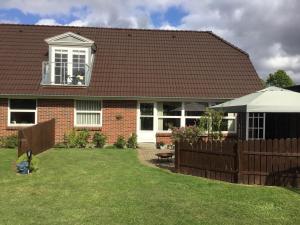 a house with a brown roof and a fence at Glejbjerg Bed and Breakfast in Glejbjerg