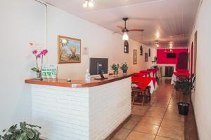 a bar in a restaurant with red tables and chairs at Pousada Chale Suísso in Ilhabela
