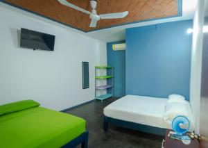 1 dormitorio con 1 cama y ventilador de techo en Hostal Azul y Blanco en Santa Cruz - Huatulco