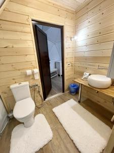a wooden bathroom with a toilet and a sink at Eco-turbaza Green Kolobok in Aktash