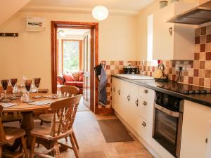 a kitchen with a table and a dining room at Pool Barn in Craven Arms