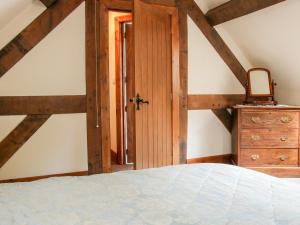 a bedroom with a bed and a wooden door at Pool Barn in Craven Arms