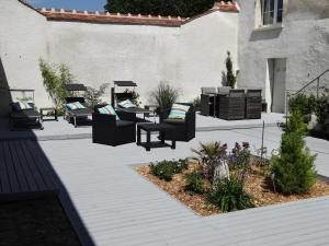 a patio with furniture and a table and chairs at Les Petites Tuileries in Bray-sur-Seine