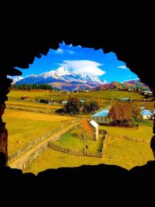 a view of a farm with mountains in the background at Shorena's Homestay in Tsvirmi