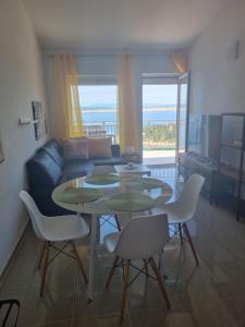 a living room with a table and chairs and a couch at Apartmani Tanja in Dramalj