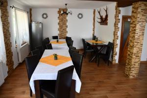 a dining room with two tables and black chairs at VILA SIMONA in Moieciu de Sus