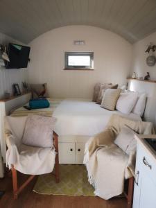 Waltham on the Wolds的住宿－Fair Farm Hideaway，卧室配有一张带两把椅子的白色大床