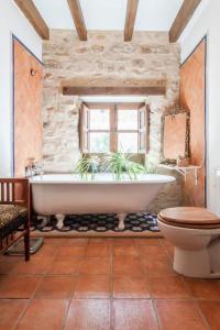 a stone bathroom with a tub and a toilet at Casa Cerros de Úbeda 1630 in Úbeda
