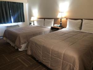 a hotel room with two beds and a window at Houston Motor Inn in Houston