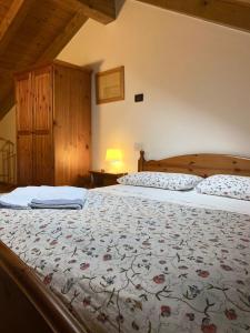 two beds in a bedroom with a bedspread with flowers at Casa Meneghin in Erto