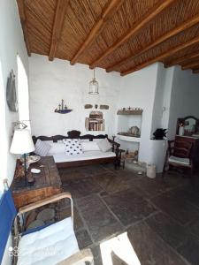 a room with a bed and a table and a couch at Traditional stone house with breathtaking view in Serifos Chora