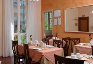 a dining room with tables and chairs and a mirror at Relais Dante e Beatrice in Florence