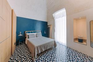 a bedroom with a bed and a blue wall at Infinito Bianco in Polignano a Mare