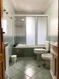 y baño con aseo, bañera y lavamanos. en Xavega Apartment en Torreira