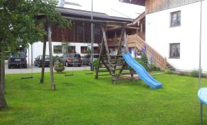 a playground with a blue slide in a yard at Ferienwohnung Zottnerhof in Frasdorf