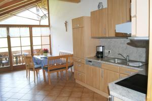 a kitchen with a table and a dining room at Ferienwohnung Zottnerhof in Frasdorf