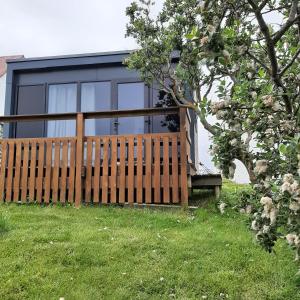 eine Holzbank vor einem Haus in der Unterkunft Hagi 1 Guesthouse in Aðaldalur