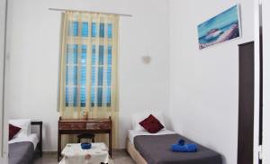 a room with two beds and a table and a window at Marika's Traditional House in Agios Nikolaos