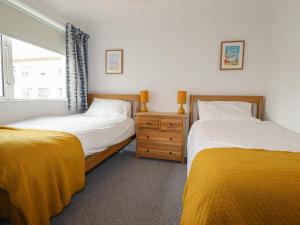 a bedroom with two beds and a window at 7 Europa Court in Newquay