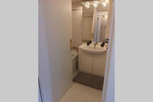 een witte badkamer met een wastafel en een spiegel bij Studio climatisé - belle vue mer-piscine in Beausoleil