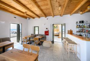 a restaurant with wooden ceilings and tables and chairs at Selinitsa Residence Mani in Agios Nikolaos