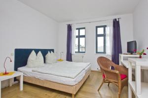 1 dormitorio con 1 cama y 1 silla en F-1065 Brunnenaue Haus Terrasse, für Gruppen geeignet en Sagard