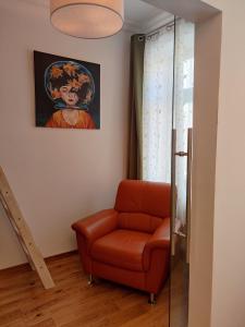 una sala de estar con una silla y una pintura en 3Raumwohnung in Leipzig am Völkerschlachtdenkmal, en Leipzig