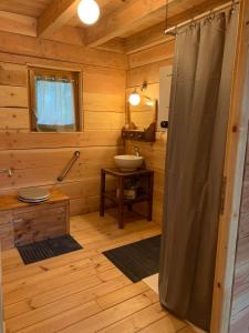- une salle de bains pourvue d'une douche dans une cabine en bois dans l'établissement Les Cabanes de Lou-loup écologiques et autonomes, à Anzème