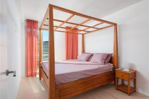 Un dormitorio con una cama con dosel y una ventana. en Casa REWA, en Puerto de Alcudia