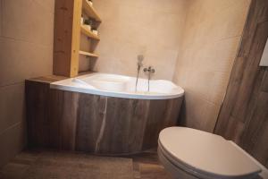 a bathroom with a tub and a toilet and a sink at Roubenka Valachy in Nový Hrozenkov