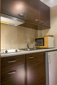 a kitchen with a sink and a microwave at Athina Stunning Elounda View Apartment in Elounda