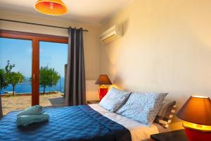 a bedroom with a bed with a view of the ocean at Athina Stunning Elounda View Apartment in Elounda