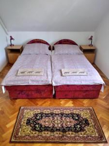 a bedroom with two beds and two rugs on the floor at Csokonyavisontai Napsugár Vendégház in Csokonyavisonta